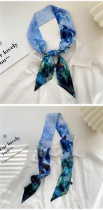 Detail of blue floral silk scarf tied elegantly on a white cotton shirt collar