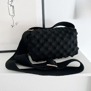 Detail of black knit popcorn bag showing 3D bubble texture and wide shoulder strap