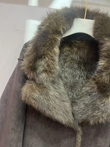 Détail du col en fausse fourrure marron et de la texture suédée d'une veste d'hiver chic