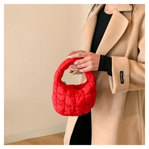 Detail of red quilted cloud bag paired with a khaki trench coat for a stylish look