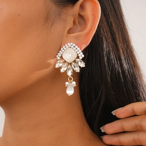 Close-up of elegant resin pearl earrings with marquise crystals on a female model