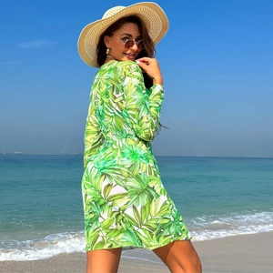 Sheer long-sleeved beach cover-up featuring vibrant green tropical leaf print and elastic waist