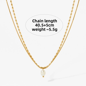 Close-up of double-layer gold snake chain necklace with a white teardrop pearl pendant