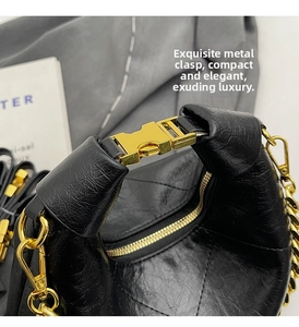 Close-up of golden metal clasp and chain on black quilted leather baguette bag