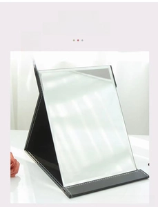 Foldable desktop makeup mirror with black faux leather casing and white stitching