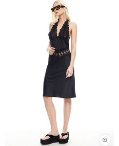 Détail de dentelle noire sur une mini robe dos nu avec décolleté plongeant en V