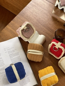 Flat lay of corduroy cable organizer bags in multiple colors on a wooden desktop