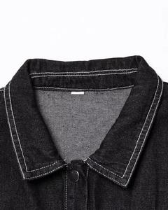 Detail of denim dress collar with contrast stitching and metallic button closure