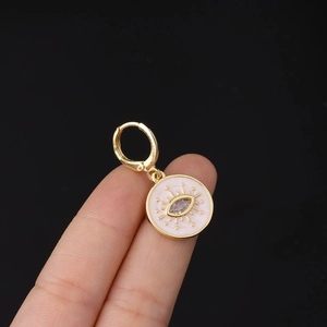 Detail of pink enamel evil eye charm hoop earring featuring white marquise stone