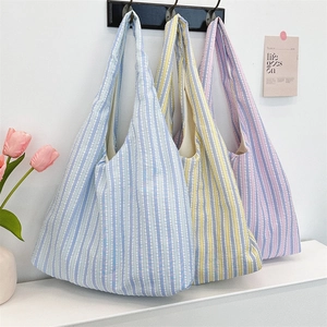 Detailed texture of colorful striped canvas tote bags hanging in a lifestyle setting