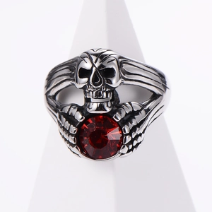 Punk gothic skull ring in vintage silver with a large round red zircon stone on stand