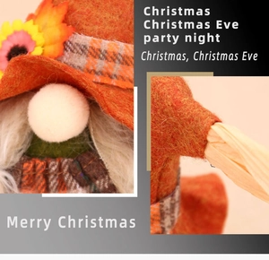 Close-up of harvest gnome doll with orange felt hat and maple leaf decorations