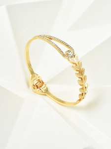 Macro detail of golden wheat leaf bracelet with zircon drops on a geometric background