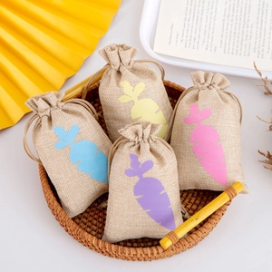 Linen drawstring pouches with colorful carrot silhouettes inside a rustic wicker basket