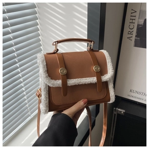 Detailed view of brown PU leather bag with white plush trim and golden round metal buckle