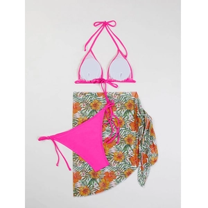 Flat lay of neon pink three-piece bikini set with tropical floral print sarong cover-up