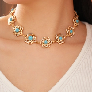 Detail of vintage flower necklace with turquoise stones and rhinestones on model