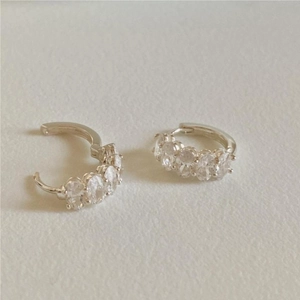 Macro shot of silver 925 hoop earrings with clear oval stones and snap closure detail