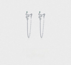 Close-up of S925 silver snake earrings with green gem eyes and sparkling pavé tassels