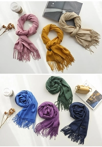 Flat lay of colorful cashmere shawls with tassels and stylish lifestyle accessories