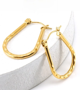 Close-up of golden hammered stainless steel U-shaped earrings with secure latch back