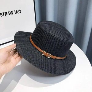 Detail of black woven straw hat with brown leather band and gold buckle accent