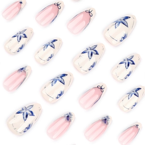 Blue and white almond press-on nails featuring elegant floral and bow tie patterns