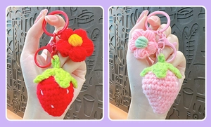 Close-up of handmade crochet strawberry and flower keychains in pink and red colors
