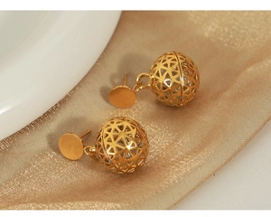 Macro shot of 18K gold plated hollow bead earrings with zircon inlays and star patterns