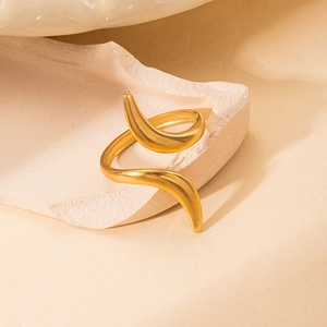 Close-up of a matte gold snake-shaped stainless steel ring on a textured stone base