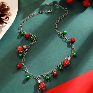 Detailed view of Christmas necklace with red and green bell charms on festive background
