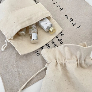 Detailed macro view of natural cotton linen canvas drawstring storage bags for cosmetics