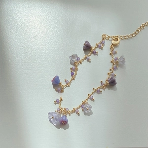 Close-up of floral crystal necklace with purple resin beads and a gold chain