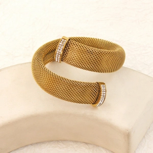 Golden mesh twisted bangle featuring sparkling rhinestones on minimalist stone props