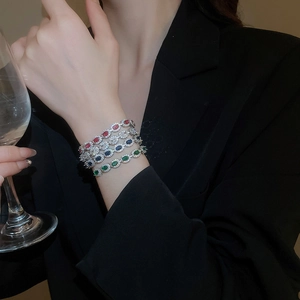 Quatre bracelets en zircon colorés avec pierres ovales portés en pile sur le poignet du mannequin