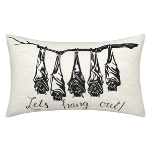 Detail of beige linen pillow cover with five black hanging bats and Let's hang out text