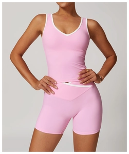 Close-up of pink yoga top and shorts featuring white contrast trim and high-stretch fabric