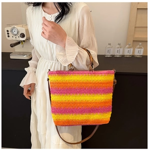 Detail of colorful striped woven straw bag with bamboo handles and shoulder strap