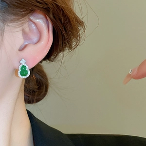 Close-up of elegant small green gourd stud earrings with cubic zirconia on model