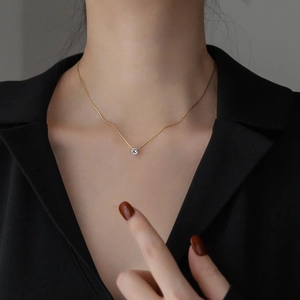 Minimalist gold six-prong solitaire zircon pendant necklace worn on a female model