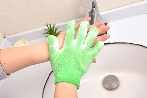 Exfoliating green scrub glove in use with rich foam on skin for deep body cleaning