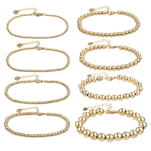 Set of eight gold-plated stainless steel beaded bracelets in various bead sizes