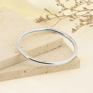 Detailed close-up of 4mm silver stainless steel bangle showing hinge clasp and mirror finish