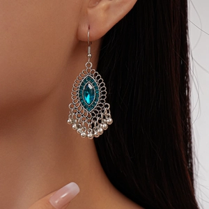 Detail of vintage bohemian silver fringe earrings with dark blue gems on a model