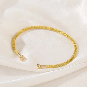Macro detail of the woven mesh texture and golden finish on this stylish open cuff bracelet