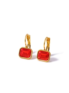 Detailed view of gold hoop earrings featuring a rectangle red zircon gemstone drop