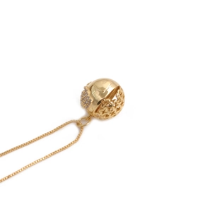 Collier avec pendentif sphérique doré orné de motifs ajourés et de cristaux de zircone