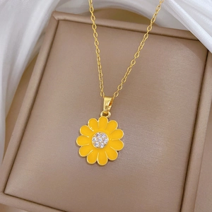 Detail of gold sunflower necklace with yellow daisy pendant and sparkling crystals