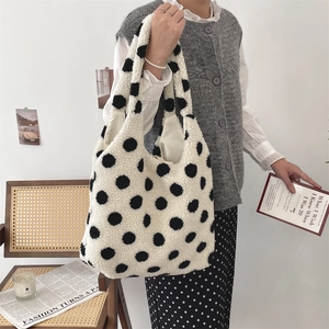 Detail der weichen Plüschtasche mit schwarzen Punkten auf weißem Webpelzmaterial