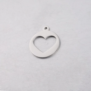 Macro detail of silver stainless steel circular pendant with heart-shaped cutout and top loop